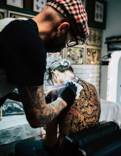 reportage photographique d'un tatoueur qui essuie le tatouage d'un dos, réalisé par un photographe à Annecy