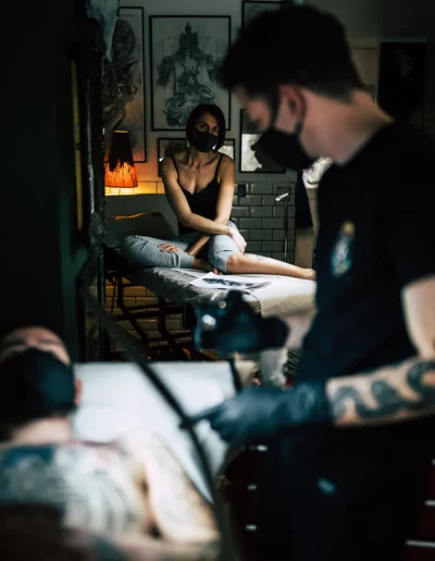 reportage photographique d'une femme qui regarde un tatoueur, réalisé par un photographe à Annecy