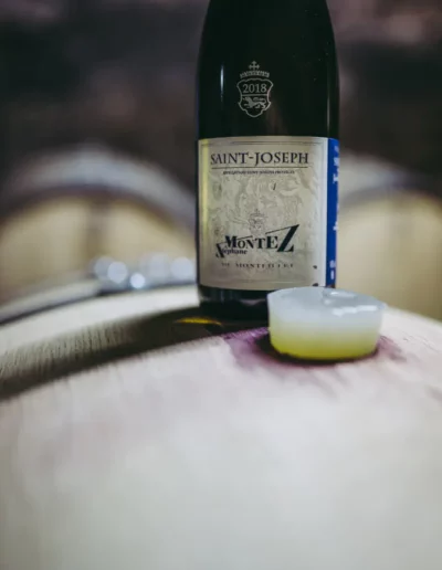 reportage photographique d'une bouteille de vin Saint-Joseph sur un tonneau de vin, réalisé par un photographe à Annecy
